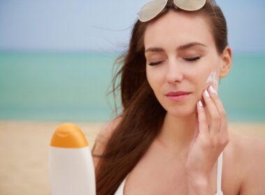 young beautiful woman applying sun cream for sun protection